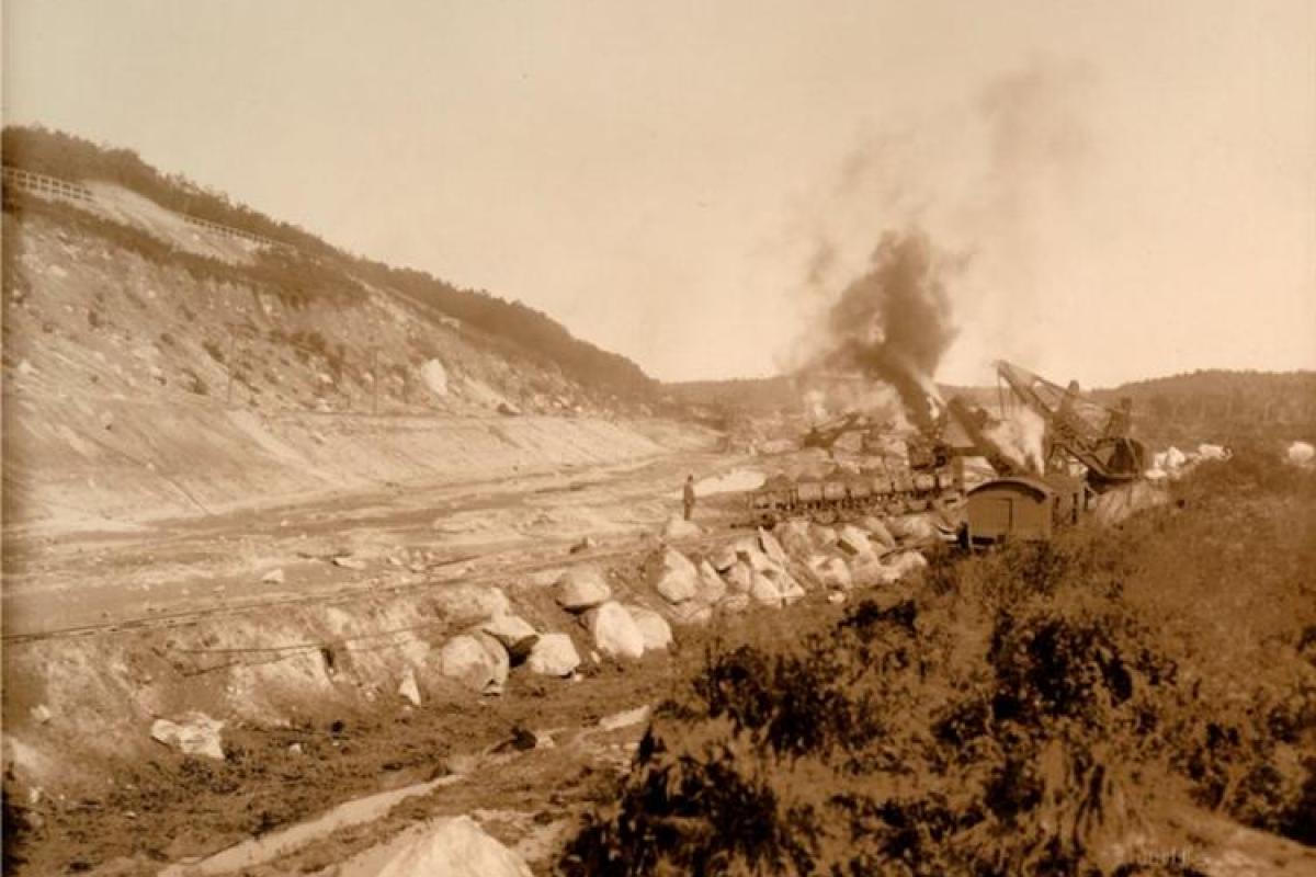 Working Along - The steam shovel dredges out the Monument River, while rocks & spoils are taken out via small rail cars.
