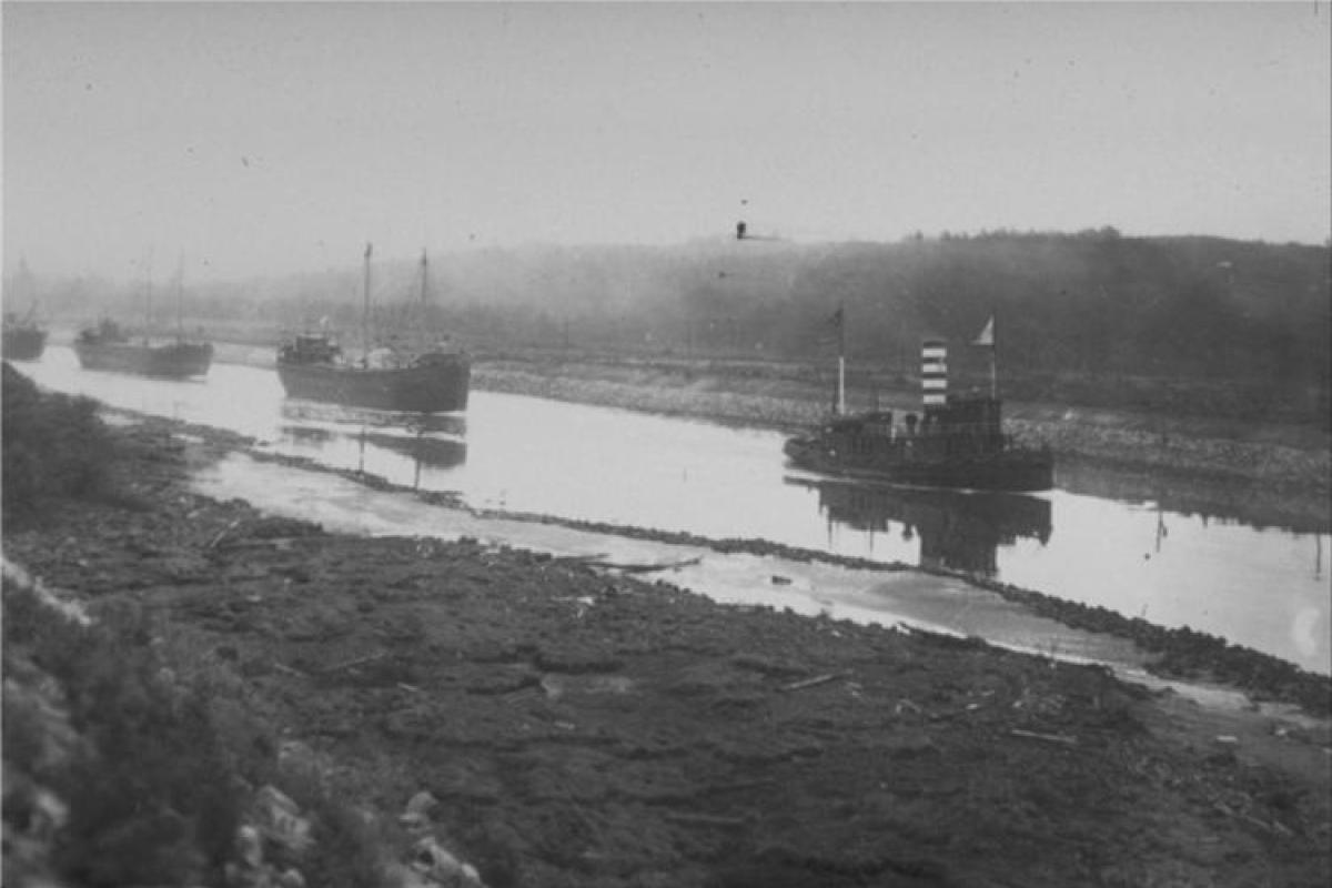 A Tight Squeeze! - When the Canal first opened, it could only accommodate one way traffic at any time. Here you can clearly see just how narrow it was, with a string of masted vessels following a tug boat.